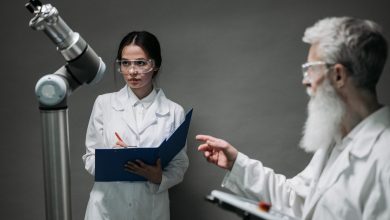 Cientistas de jaleco analisam um equipamento robótico em um laboratório de pesquisa.