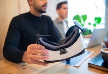 Profissionais exploram um headset de realidade virtual em um ambiente de escritório.