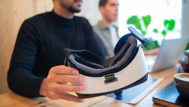 Profissionais exploram um headset de realidade virtual em um ambiente de escritório.