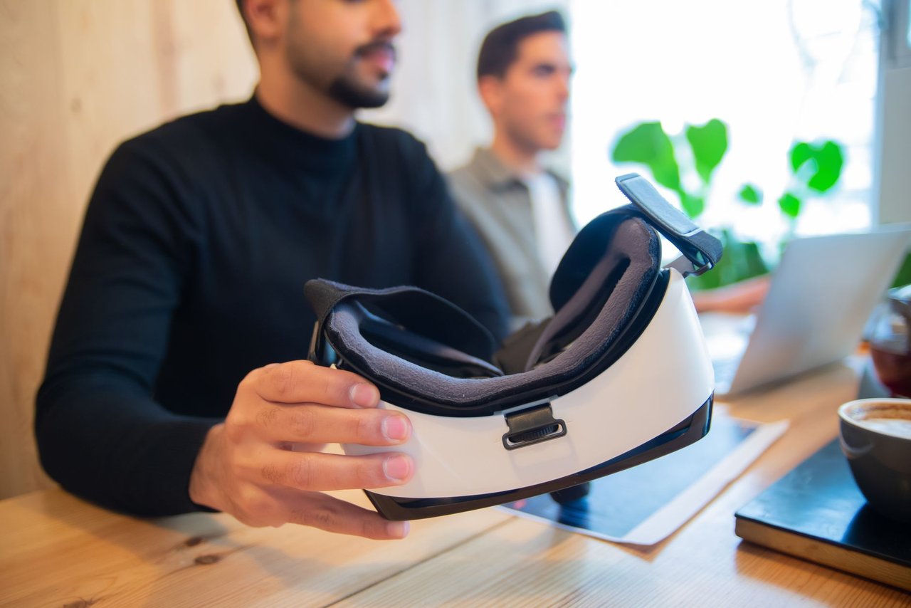 Profissionais exploram um headset de realidade virtual em um ambiente de escritório.