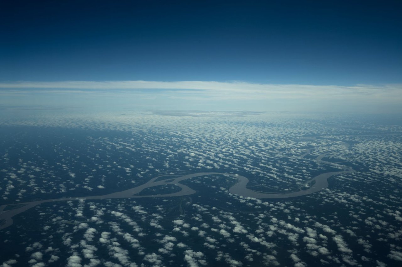 Vista aérea do rio Amazonas serpenteando por uma área de floresta preservada.